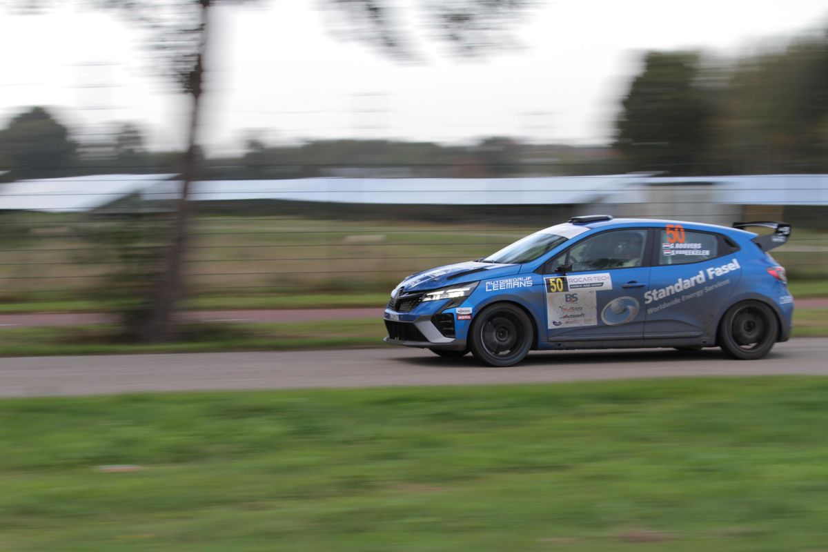 Panning shot of a blue Renault Clio Rally3 with start number 50 on an asphalt stage